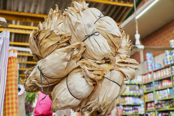 Corn husks for making tamales placed on a shelf for sale inside a market stock photo