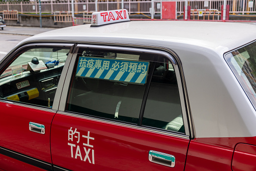 Urban Red Taxis in the street. The red taxis have the highest fares among all, and serve all areas of New Territories, Kowloon and Hong Kong Island.