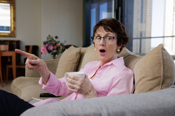 istock Woman with coffee cup sitting down and pointing with a suprised expression 1393745298
