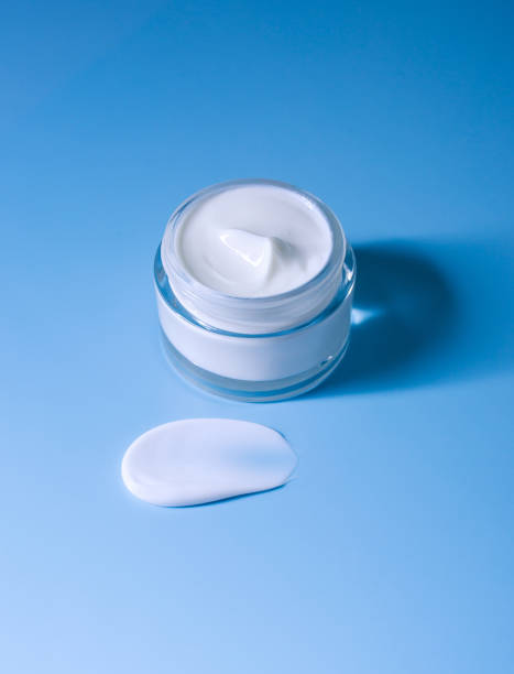 istock open jar of cream smear on blue background 1393750090