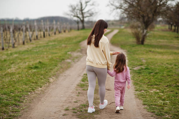 istock Back of walking mother with daughter. 1393751387