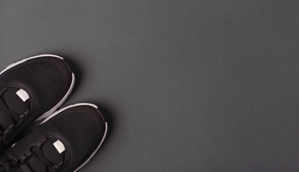 istock Black sneakers on a dark grey background. 1393753319