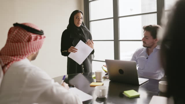 Early 20s Saudi businesswoman updating project team