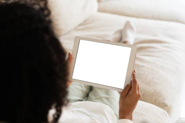 istock Mockup image of a woman holding and using tablet pc with blank desktop white screen at home. 1393756426