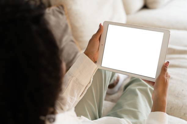 istock Mockup image of a woman holding and using tablet pc with blank desktop white screen at home. 1393756429