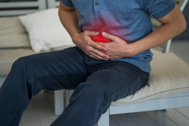 Stomach ache, man with abdominal pain suffering at home Stomach ache, man with abdominal pain suffering at home, painful area highlighted in red gastroenteritis stock pictures, royalty-free photos & images