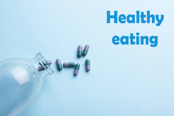 istock Bottle of vitamin and capsules on a blue background. Dietary supplements. Complementary and medical products 1393759845