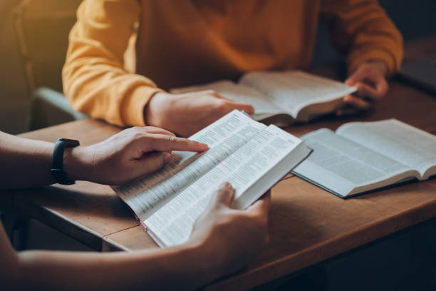 concetti di studio biblico cristiano. i gruppi di amici cristiani leggono e studiano la bibbia insieme in una casa con la luce della finestra. i seguaci stanno studiando la parola di dio nelle chiese. - christianity foto e immagini stock