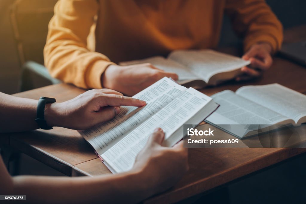 Christian Bible Study Concepts. Christian friend's groups read and study the bible together in a home with window light. followers are studying the word of God in churches. Education Stock Photo