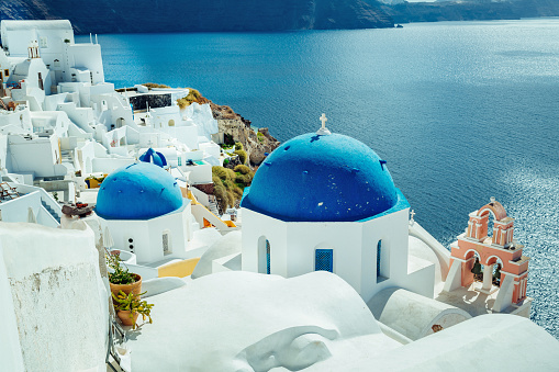 Agios Spyridon and Anastasi churches (dedicated to the Resurrection of Christ) in idyllic village Oia (Ia) on Santorini island, Greece.