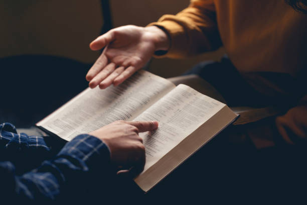 homme lisant la sainte bible en montrant le personnage et en partageant l’évangile avec un ami. sainte bible étudie la lecture ensemble à l’école du dimanche. étudier la parole de dieu avec des amis. - preacher photos et images de collection