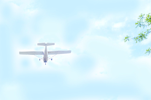 airplane flying through sky with clouds Light single-engine Cessna