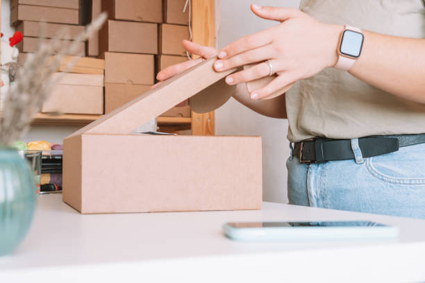 Cropped photo of woman hands packing, preparing parcel for delivery package to customers. Small business, online order stock photo