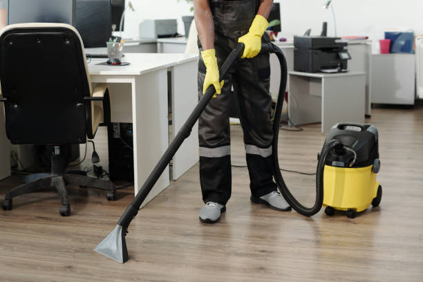 istock Young black man in uniform and yellow gloves using vacuum cleaner 1393767079