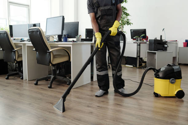Young male staff of cleaning company in black uniform and yellow gloves stock photo