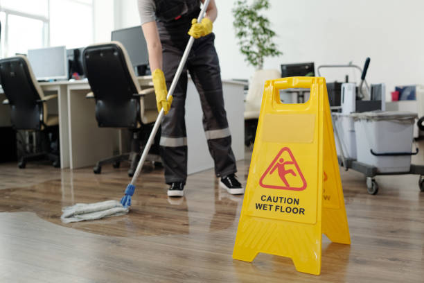 istock Yellow plastic signboard with caution warning about wet floor and female cleaner 1393767101