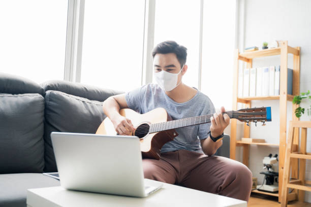 istock Working from home playing guitar learning online education video free time spending activity, self isolation quarantine lockdown staying safe in house living room protection from coronavirus covid-19 1393767165