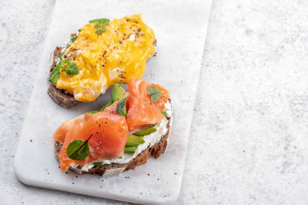 istock Scrambled eggs with smoked salmon, cream cheese and avocado on toast 1393767616