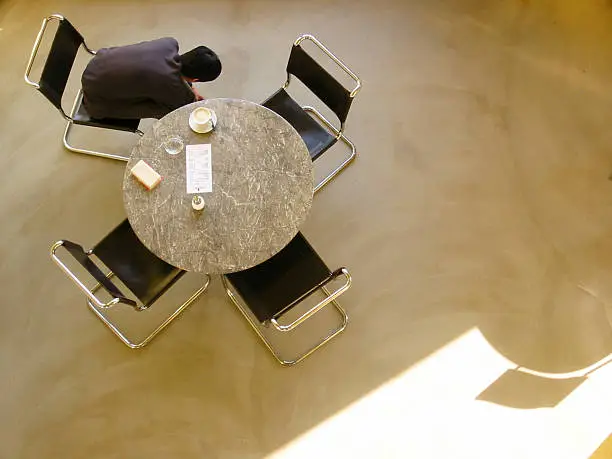 bauhaus chairs and a table in a cafe. man sitting on a chair. 