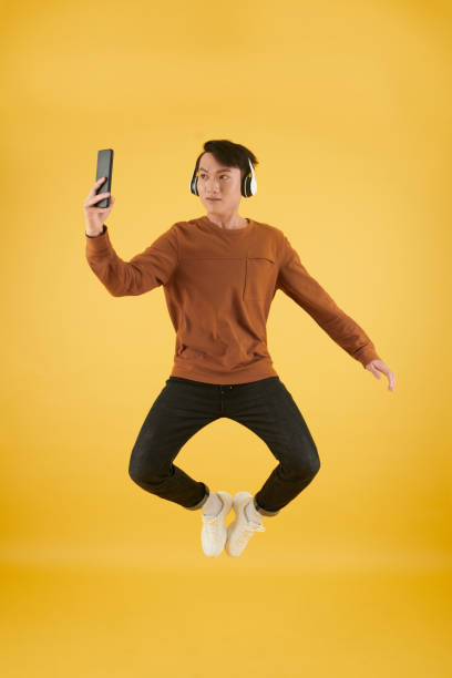 istock Man with Headphones Jumping 1393770911