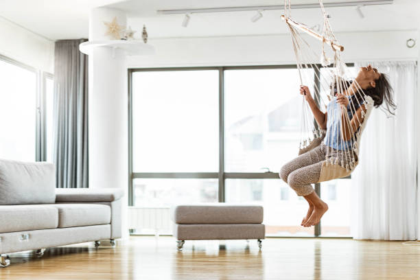 istock Carefree woman having fun while swinging at home. 1393771541