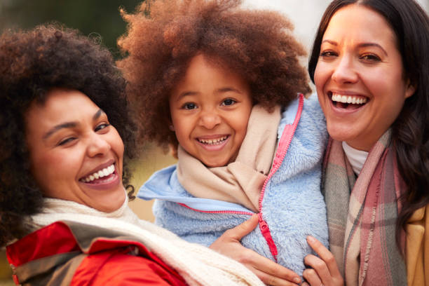 family with two mums outdoors on walk in autumn countryside with daughter - homosexual family lesbian parent imagens e fotografias de stock