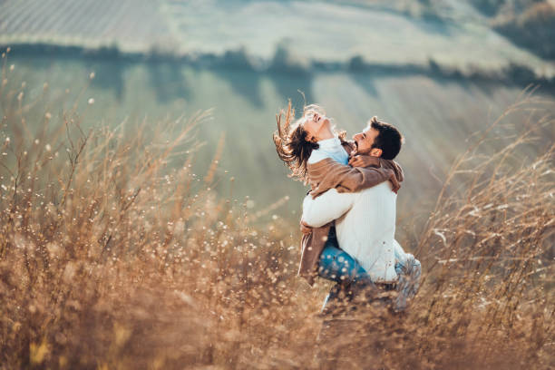istock Young happy couple having fun while playing in autumn day on a hill. 1393772475