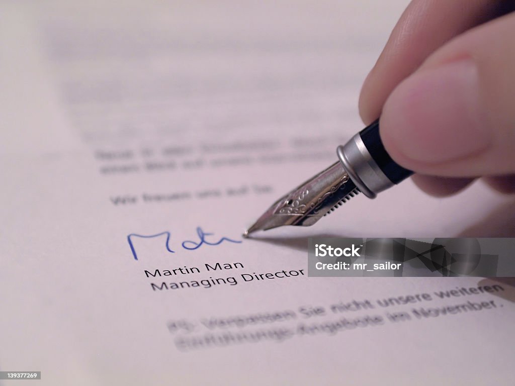 Hand writing their signature on a legal document Paperwork... fountain pen... signature. Agreement Stock Photo