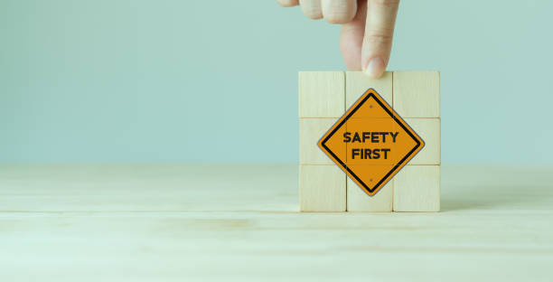 istock Safety first symbols, work safety, caution work hazards, danger surveillance, zero accident concept. Wooden cubes with smart grey background. Employees safety awareness at workplace. Safety banner. 1393772751