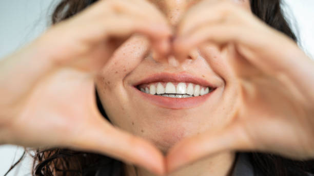 istock Woman smiling and making heart shape with her hands 1393772759