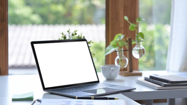 istock Home office desk with laptop computer, coffee cup and houseplant. 1393773602