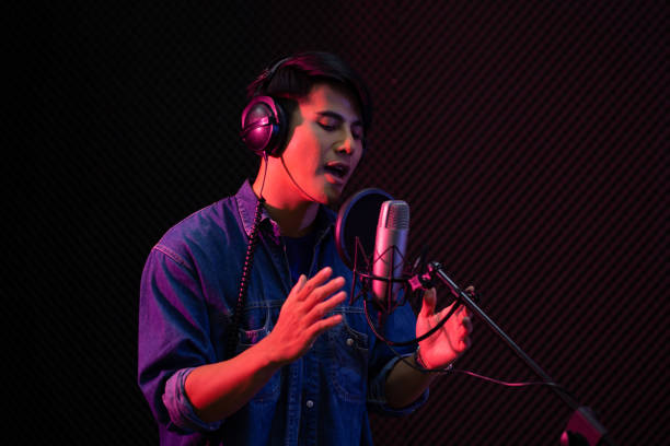 istock Asian male singer recording in the studio. 1393773838