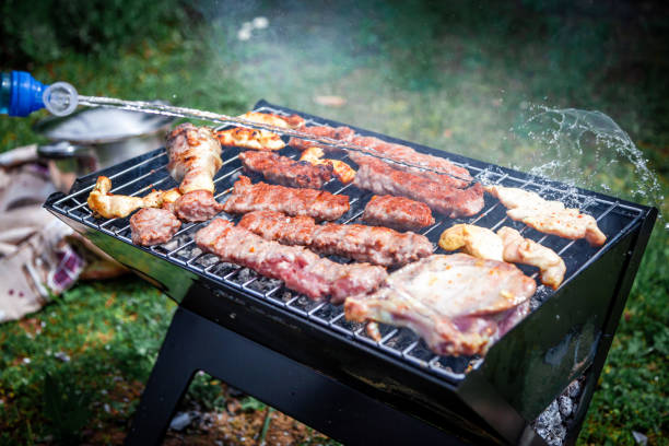istock Making barbeque in nature. Barbecue with meat and fire for holidays. 1393773958
