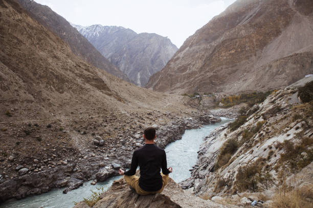 istock The man meditating at the Indus River in Himalayas mountains 1393774368