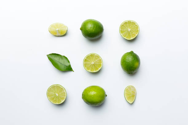 istock Lime fruits with green leaf and cut in half slice isolated on white background. Top view. Flat lay with copy space 1393775474