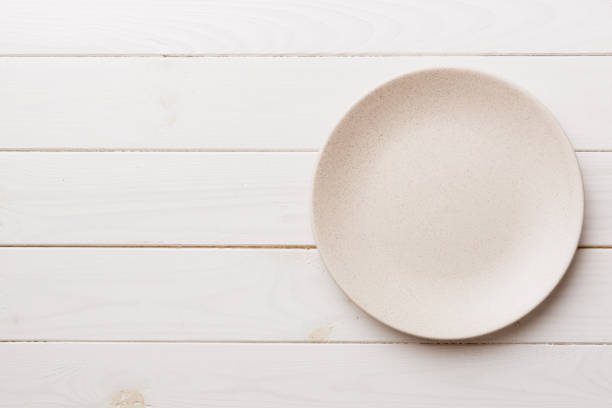 istock Top view of empty light plate on wooden background. Empty space for your design 1393775494