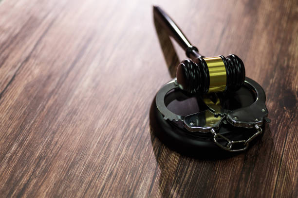 istock Gavel and handcuffs on wooden table 1393775801