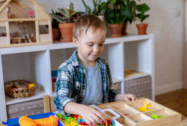 istock Happy little boy collects from the robot constructor. Montessori material. Home education. 1393776419