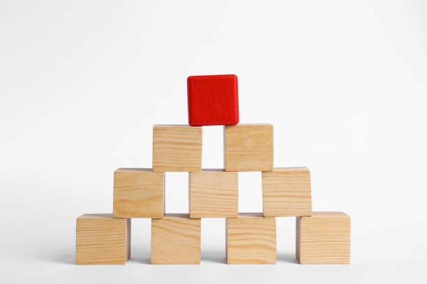 istock Blank wooden cubes and red one stacked on white background 1393776731