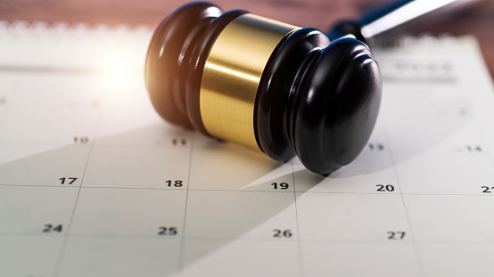 Wooden judge gavel on calendar.