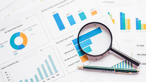 Flat lay of documents for accounting report, magnifier and pen