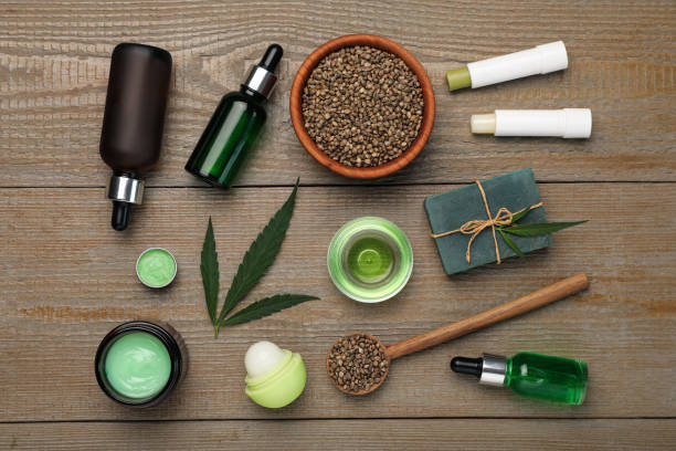 istock Hemp cosmetics and green leaves on wooden table, flat lay 1393777342