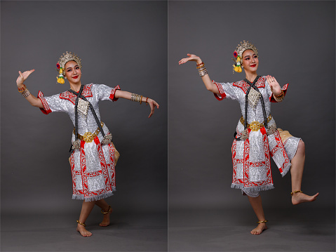 Full length of Asian Woman wear Thai Traditional Costume Dancer with beautiful design dress. Khon dance is Act Play Royal of Thailand, Studio lighting over Gray background isolated