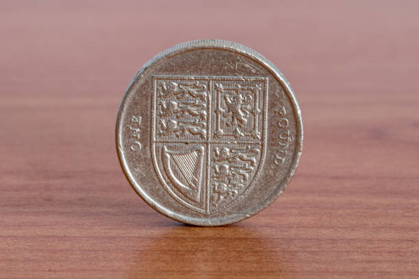 istock UK one pound coin on wooden table. 1393778991