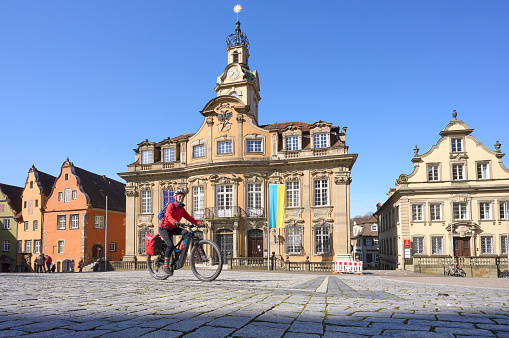 active senior woman on electric bicycle bicycle tour in downtown of Schwaebisch Hall, one of the most famous medieval cities in Baden-Wuerttemberg, Germany