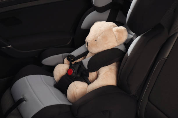 istock Teddy bear in child safety seat inside car 1393779798