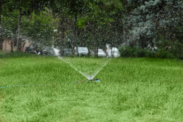 Irrigation sprinkler system at work in a back yard.