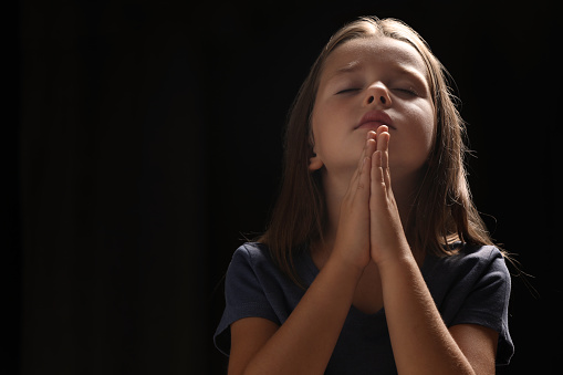 A young Asian woman prays in the church