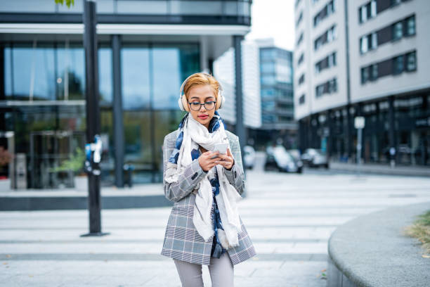 istock Young female using smart phone in the city 1393780446