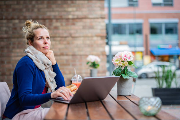 Woman using laptop while sitting in coffee bar stock photo